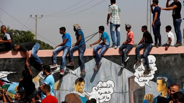 La gente observa cómo el primer ministro palestino llegan para tomar el control de Gaza.