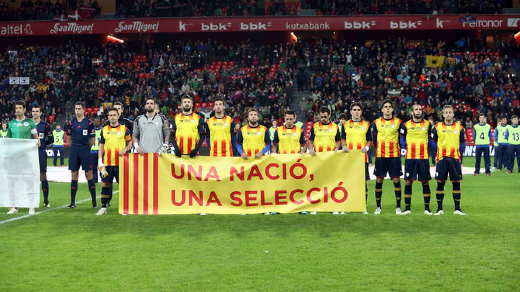 Piqué, junto a otros jugadores catalanes, porta la pancarta 'Una nació, una selecció'.