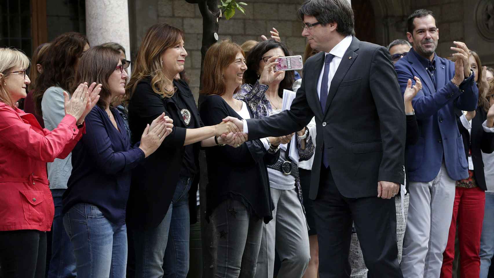 Carles Puigdemont saluda a los trabajadores de la Generalitat que le han recibido con aplausos