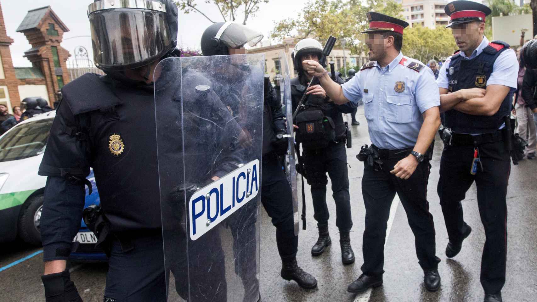 Agentes antidisturbios de la Policía Nacional y de los Mossos d' Esquadra discuten en L'Hospitalet de Llobregat.