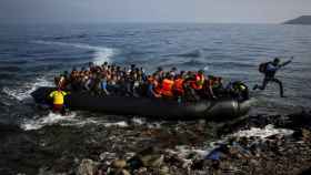 Un emigrante afgano salta de una balsa sobrepoblada en una playa de la isla griega de Lesbos.