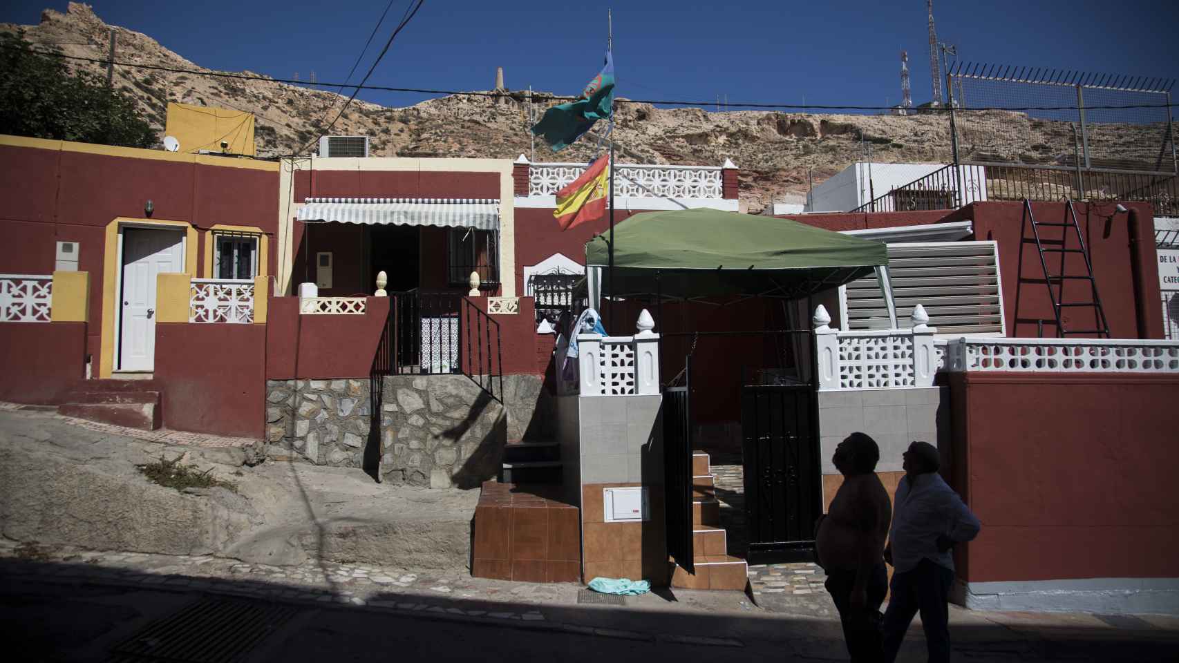 Las banderas del pueblo gitano y de España ondeando en una vivienda del barrio de la Chanca (Almería).