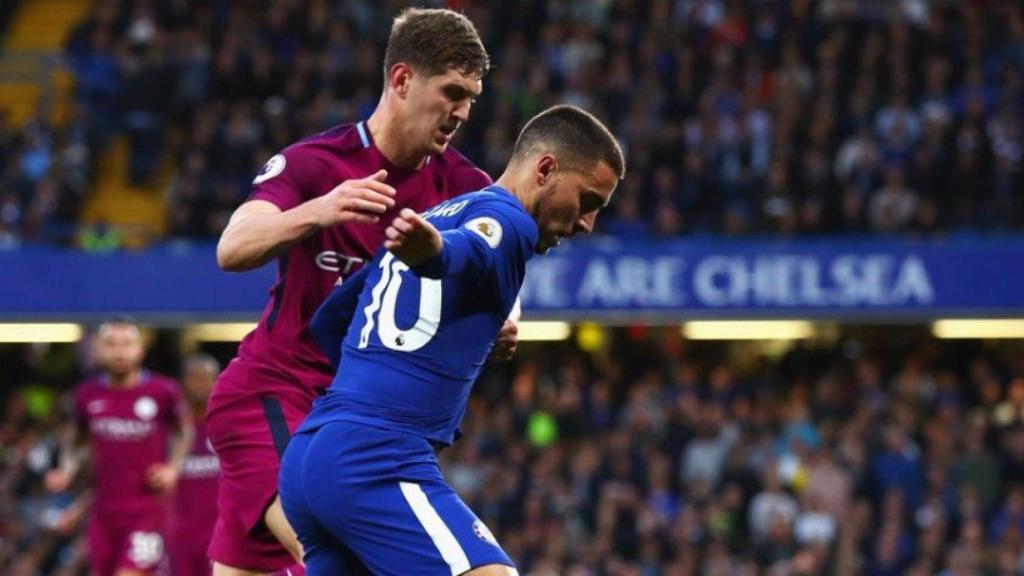 Hazard pelea un balón con Stones Twitter (@ChelseaFC)