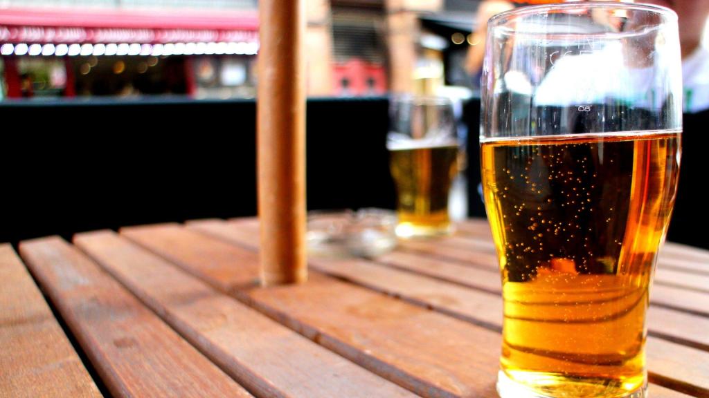 Una cerveza dispuesta para ser consumida en la mesa de una terraza.