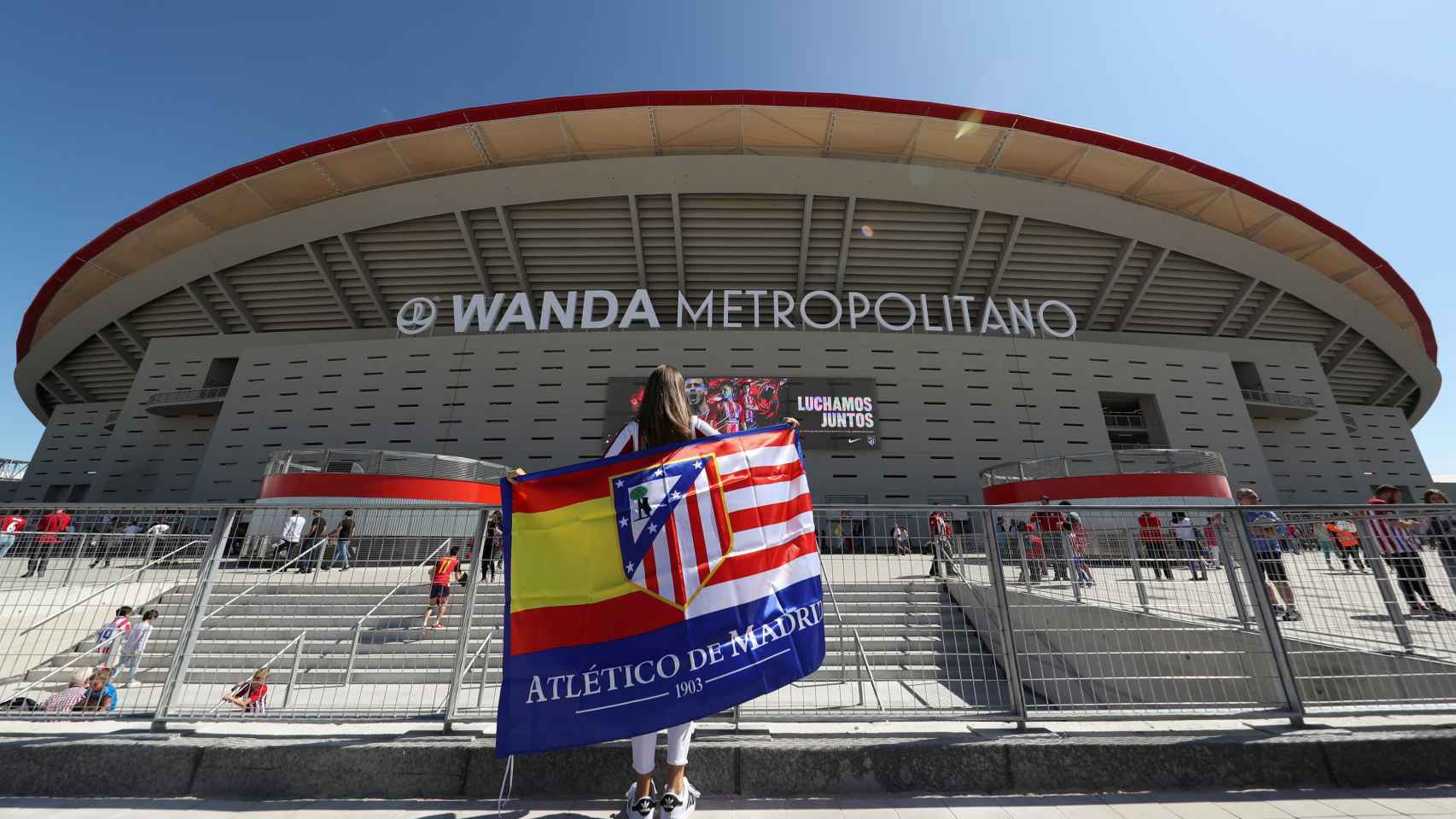 Una aficionada con la bandera de España y del Atlético frente al Wanda Metropolitano.