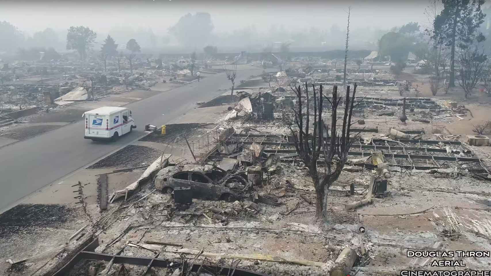 Una camioneta de correos atraviesa la ciudad de Santa Rosa, devastada por las llamas.