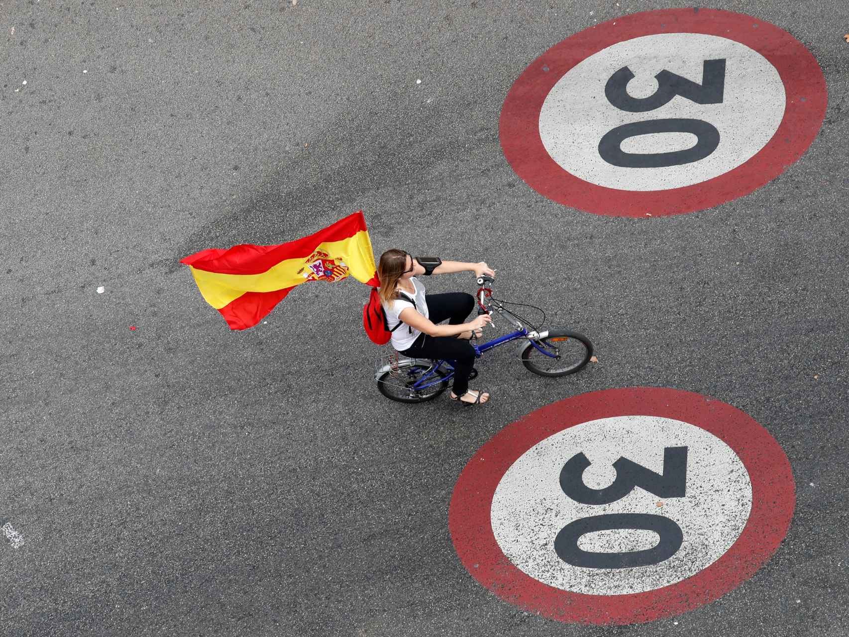 Una mujer luce una bandera de España durante el día de Fiesta Nacional en Barcelona.