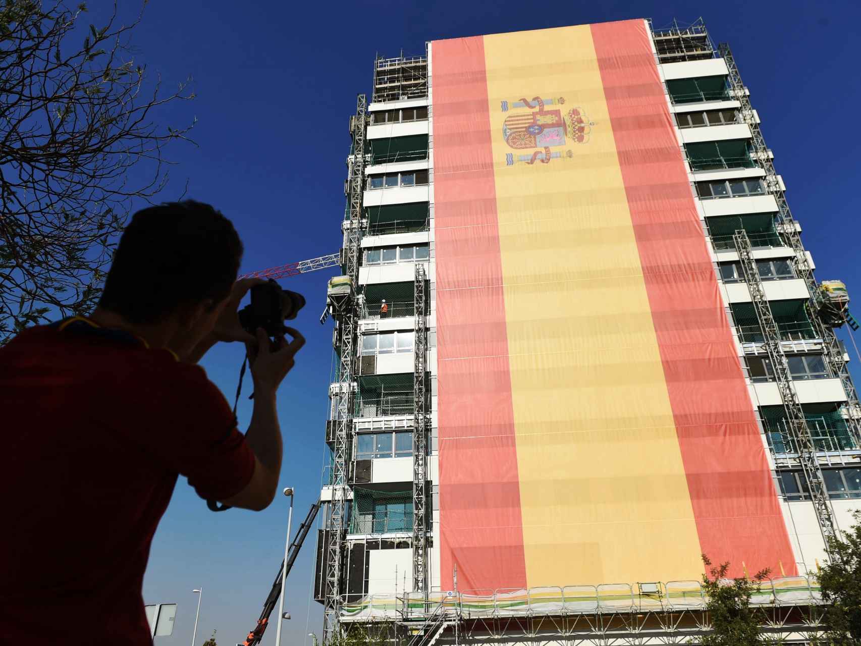 Un hombre toma una foto de la bandera instalada por el empresario César Cort.