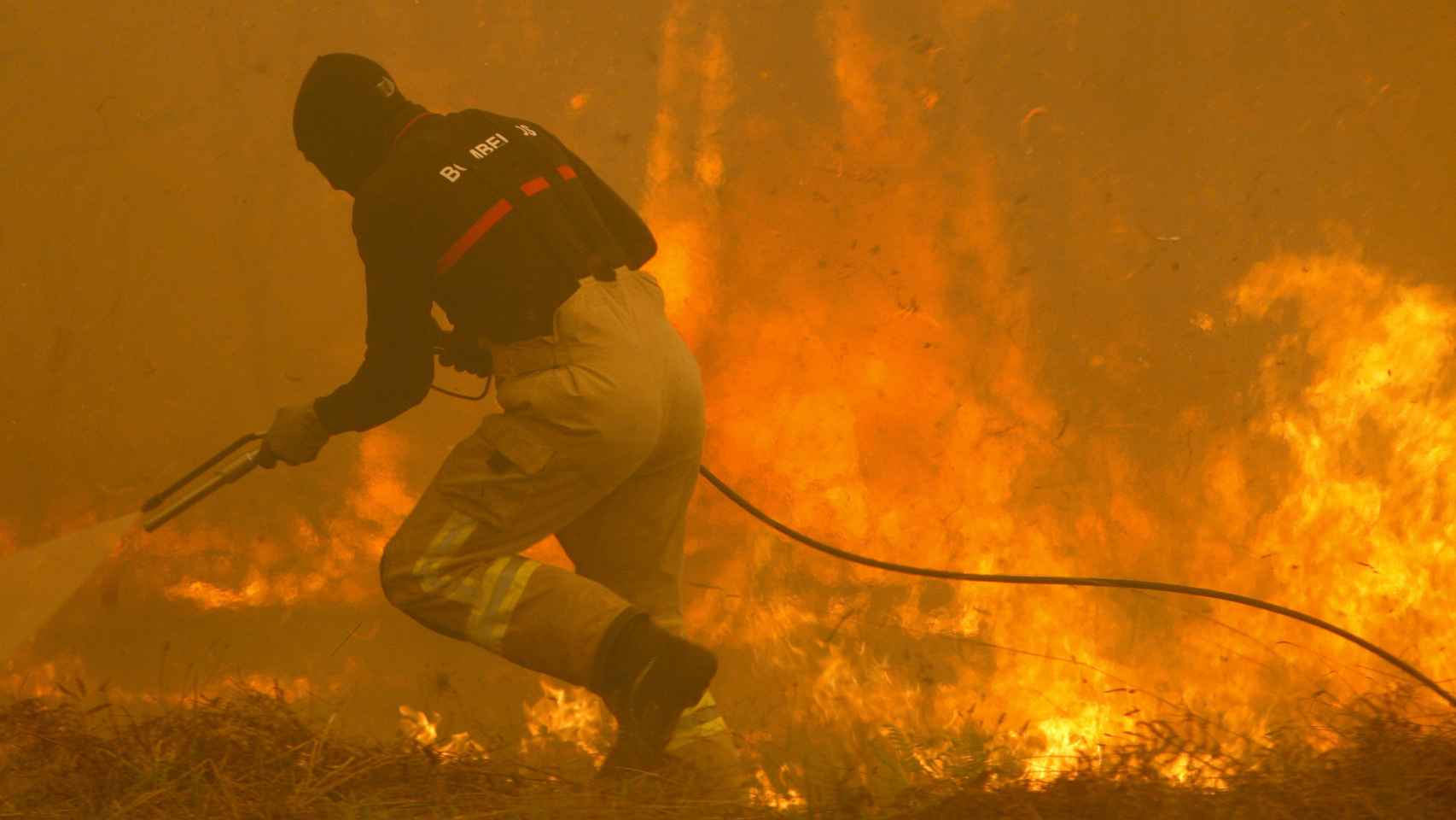 Un bombero maniobra en la lucha contra el fuego.