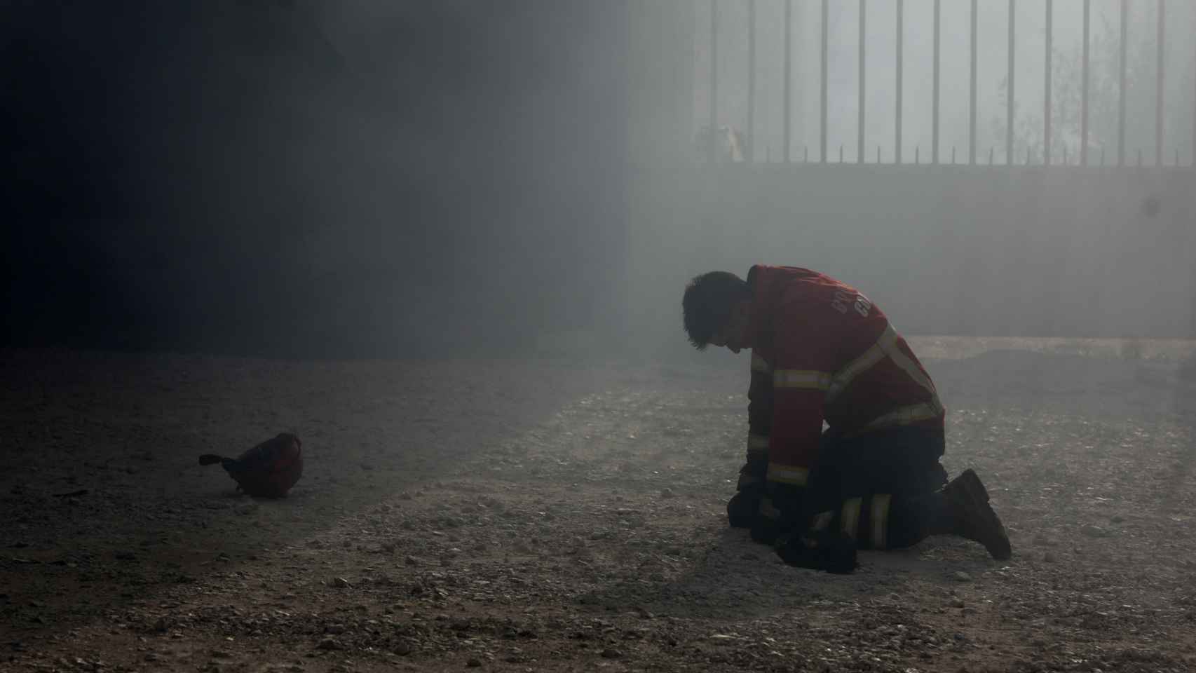 Un bombero arrodillado tras el combate al incendio en Portugal.