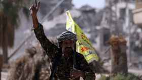 Un miliciano del FSD hace la señal de la victoria a su entrada en Raqa