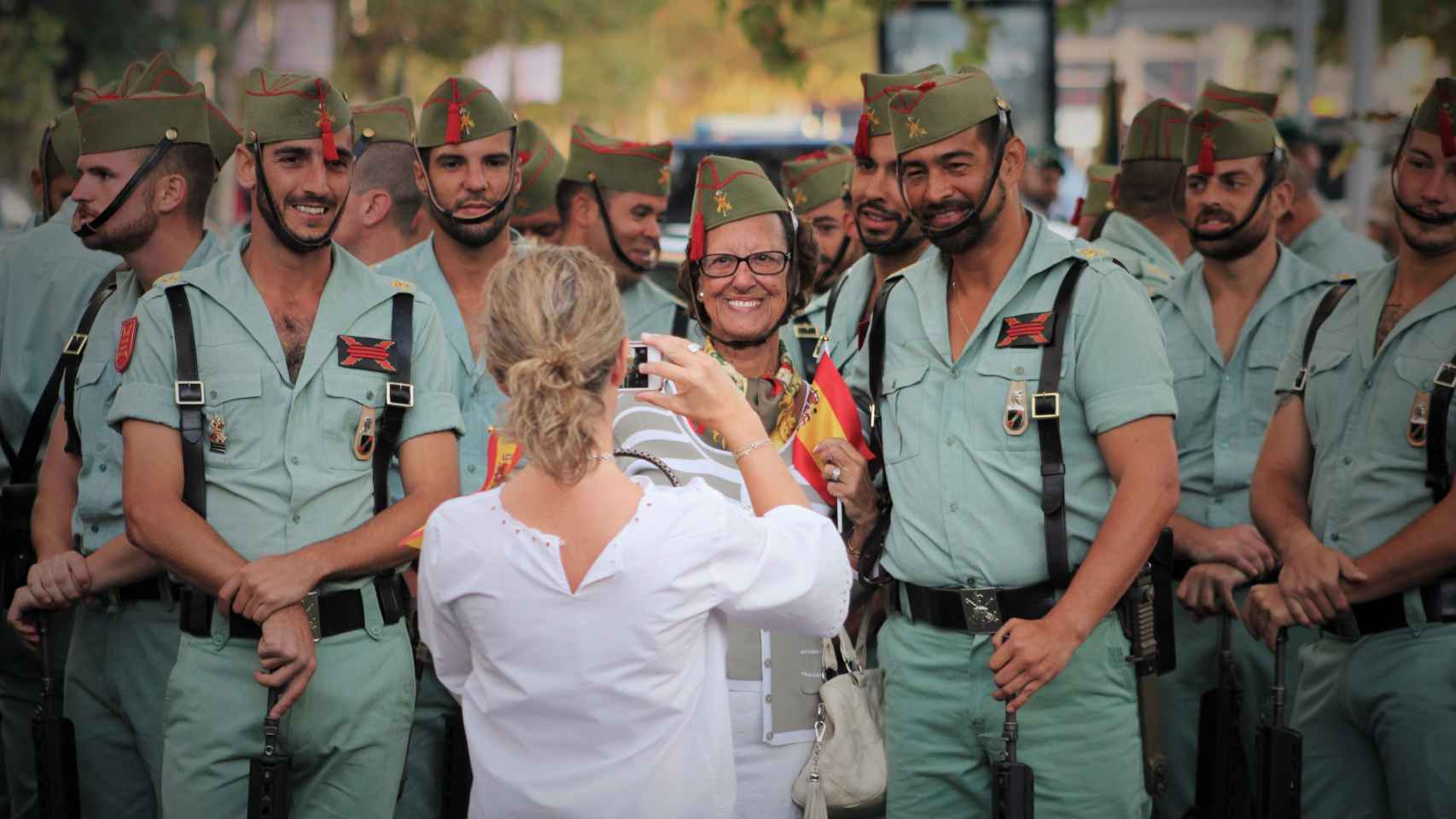 Una mujer se fotografía con los legionarios en el desfile del 12 de octubre.