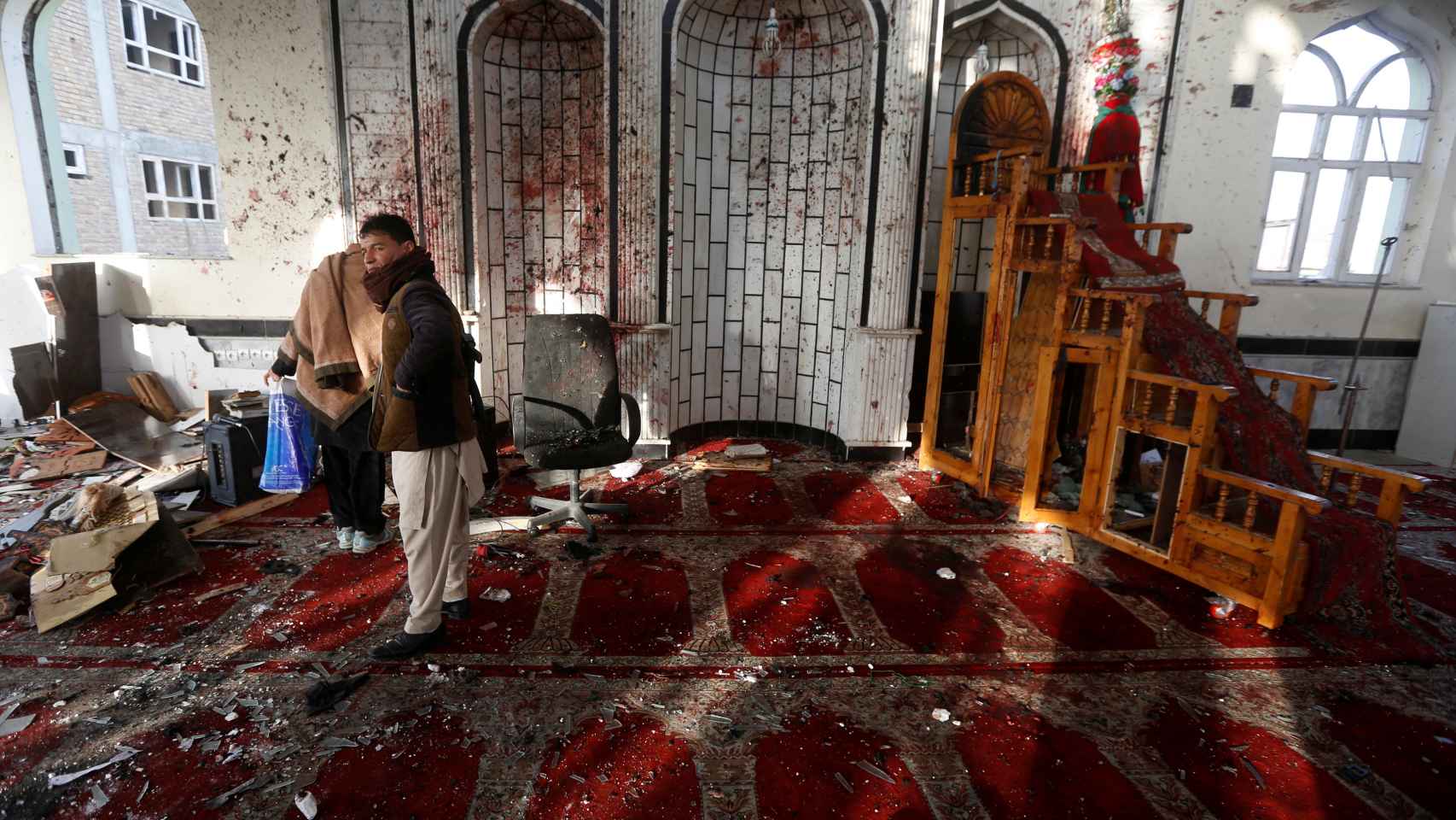 Dos afganos inspeccionan la mezquita donde se suicidó el terrorista