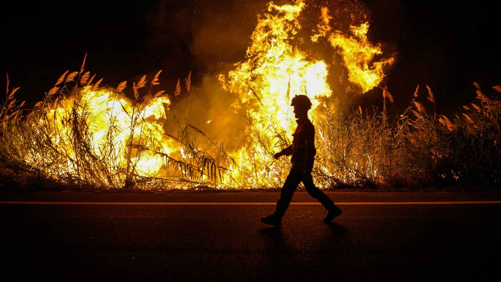 Un bombero junto a las llamas de un incendio.