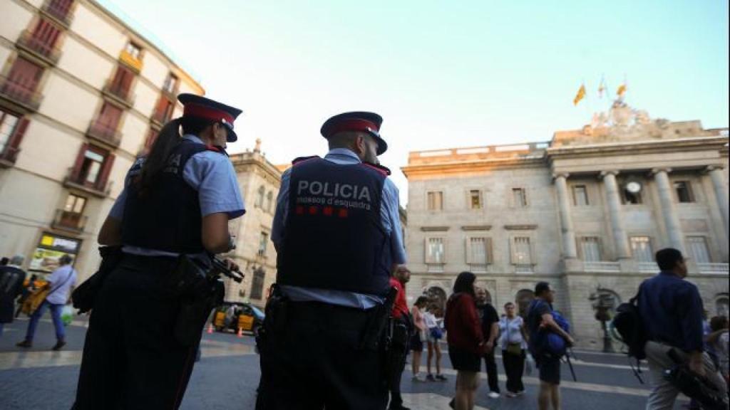 Dos Mossos d'Esquadra realizan su trabajo en la plaza de Sant Jaume de Barcelona.