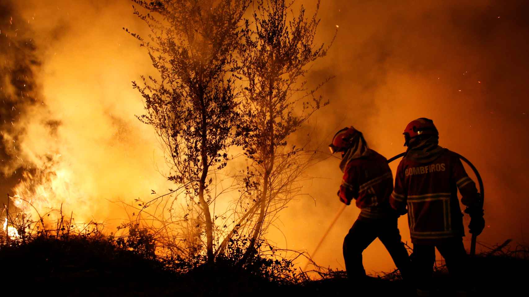 Dos bomberos portugueses combatiendo el fuego.