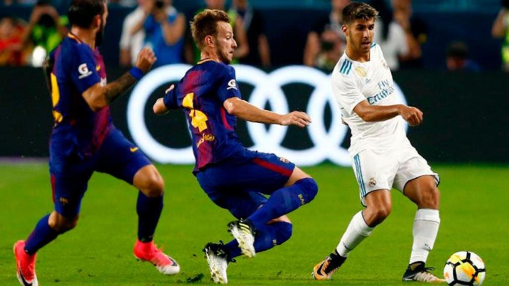 Marco Asensio evitando una entrada de Rakitic