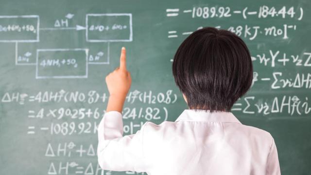 Un niño delante de un encerado.