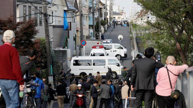 Varios curiosos congregados alrededor del apartamento donde se encontraron los cuerpos.