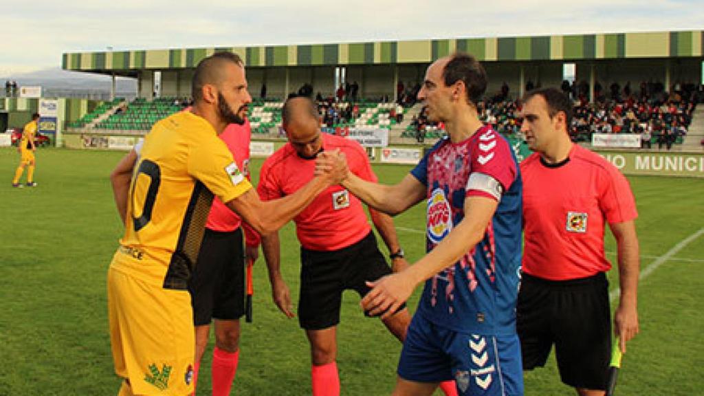 El colegiado del Gimnástica Segoviana - Ponferradina junto a los dos capitanes.