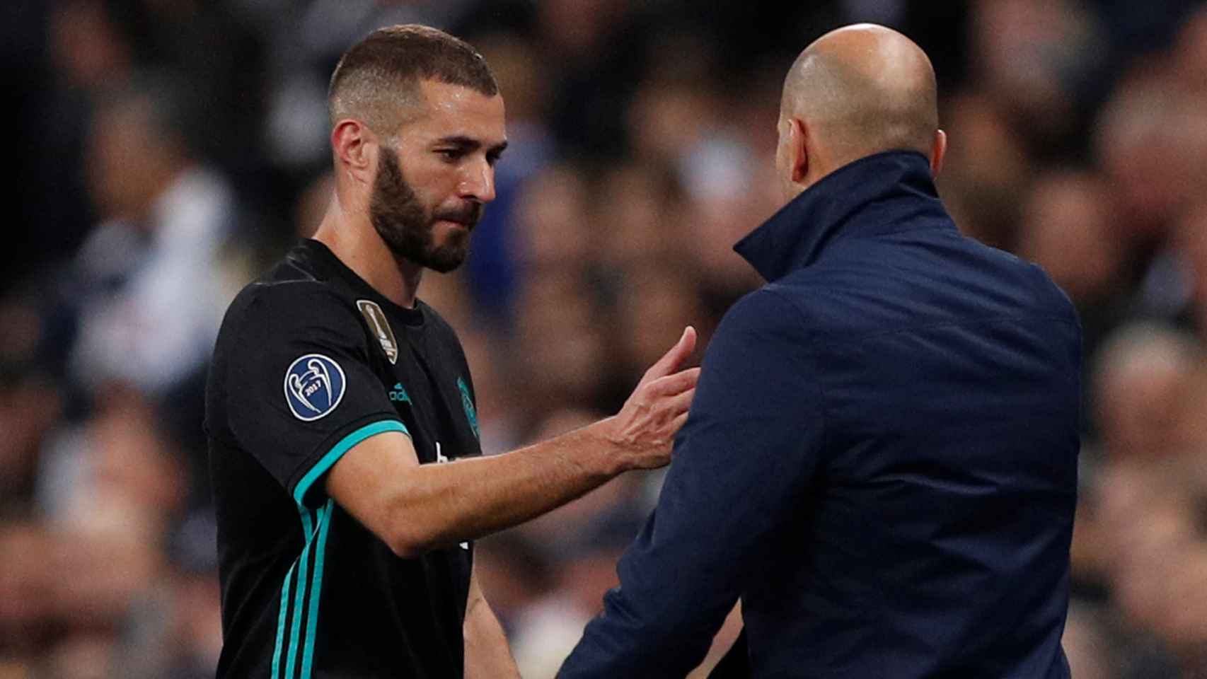 Benzema le da la mano a Zidane.
