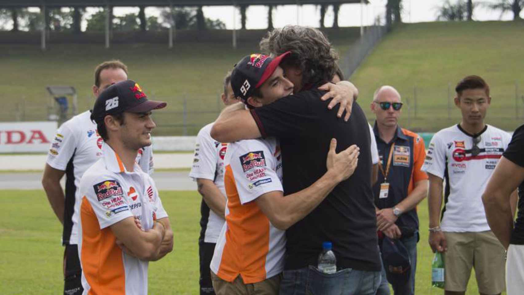 Paolo Simoncelli y Marc Márquez se abrazan en presencia de Dani Pedrosa.
