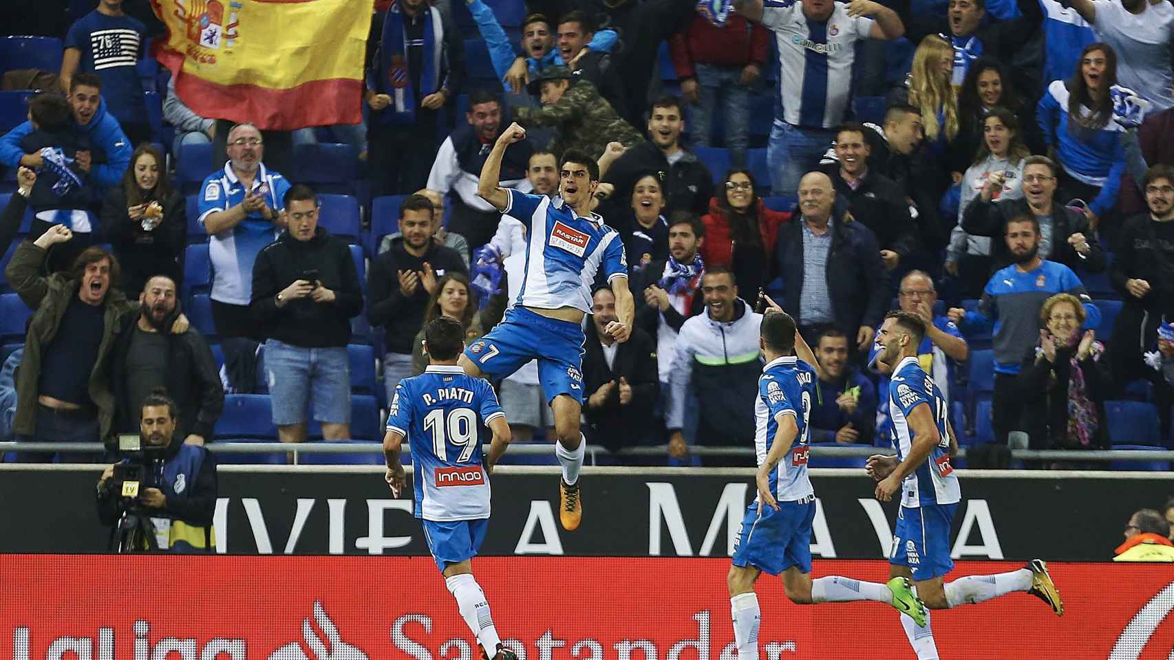 Los jugadores del Espanyol celebran un gol con una bandera de España en la grada.