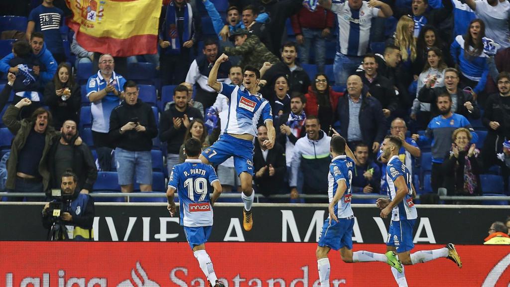 Los jugadores del Espanyol celebran un gol con una bandera de España en la grada.