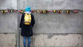 Una joven ante el muro de Berlín.