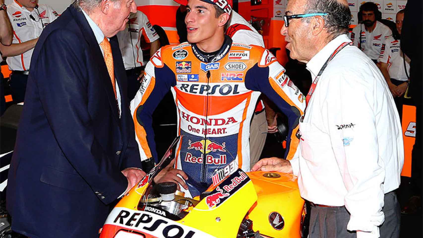 Ezpeleta (d), junto a Marc Márquez (c) y el Rey Juan Carlos, en un Gran Premio.