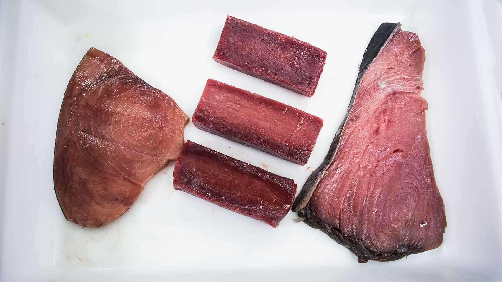 A la izquierda, un filete teñido con zumo de remolacha. En el centro, tres trozos de atún rojo de almadraba. A la derecha, un chuletón de atún rojo comprado en un mercado de Madrid.