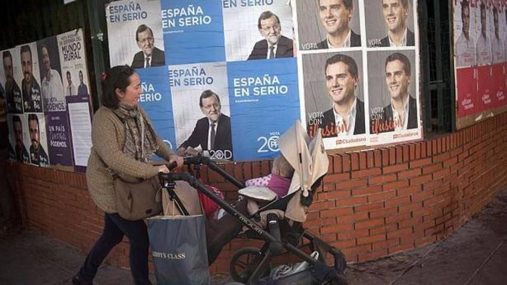 Una mujer con su bebé pasea frente a carteles electorales, en una imagen de archivo.