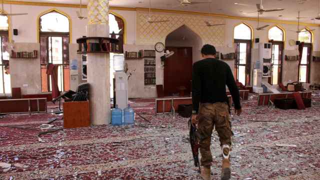 Miembro de la coalición en una mezquita dañada por un atentado suicida.