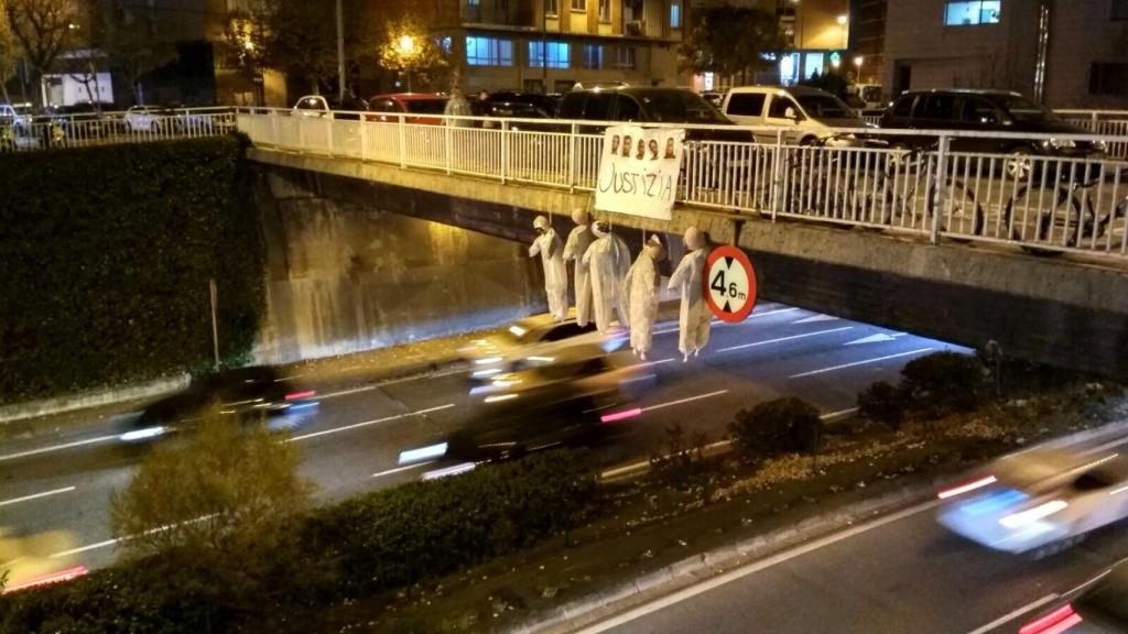 Cinco muñecos colgados de un puente de Pamplona sobre una pancarta con la foto de los cinco acusados y la palabra 'justicia' escrita en euskera.