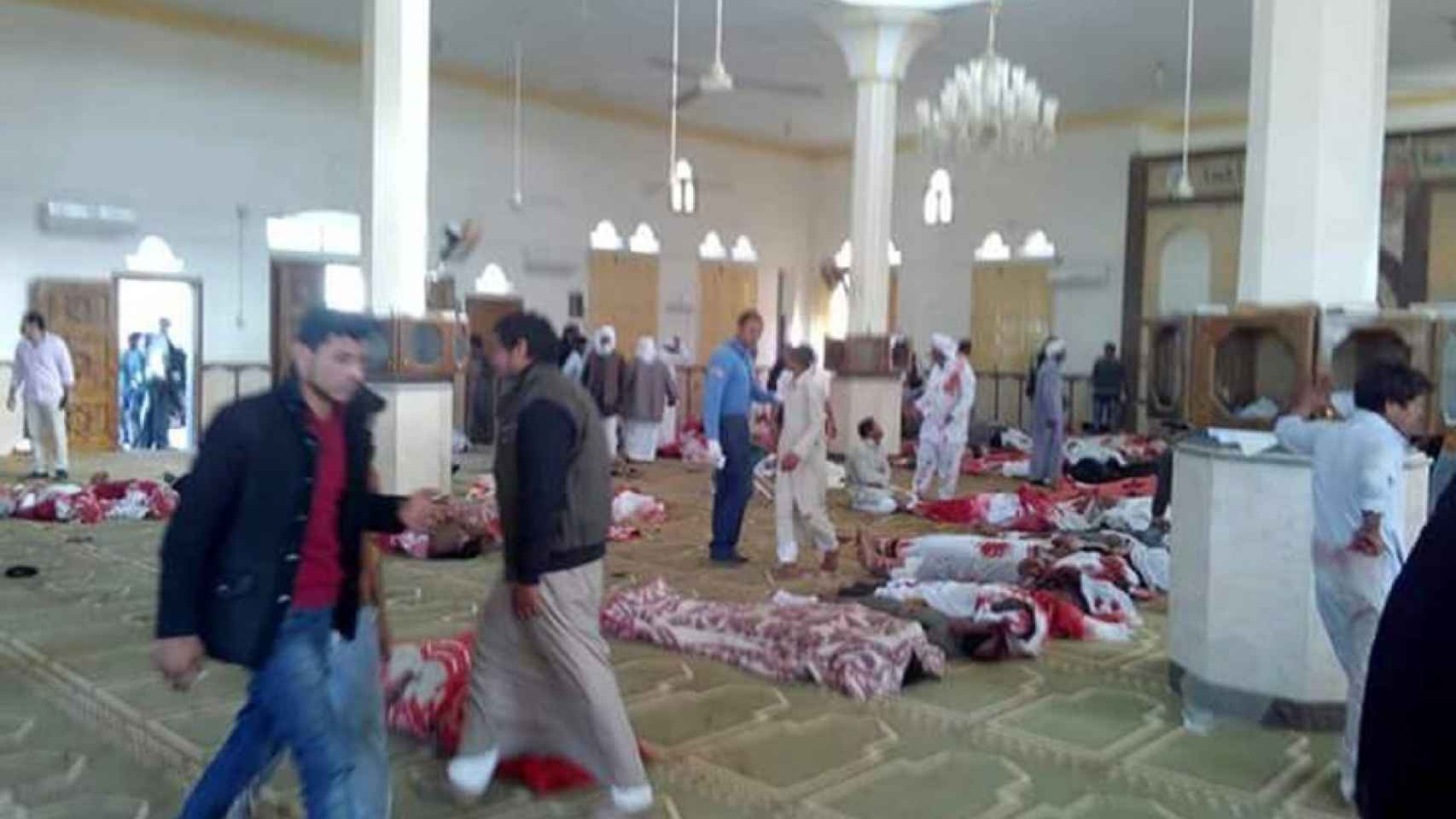 Varias personas permanecen junto a cuerpos sin vida en el interior de la mezquita en el Sinaí (Egipto)