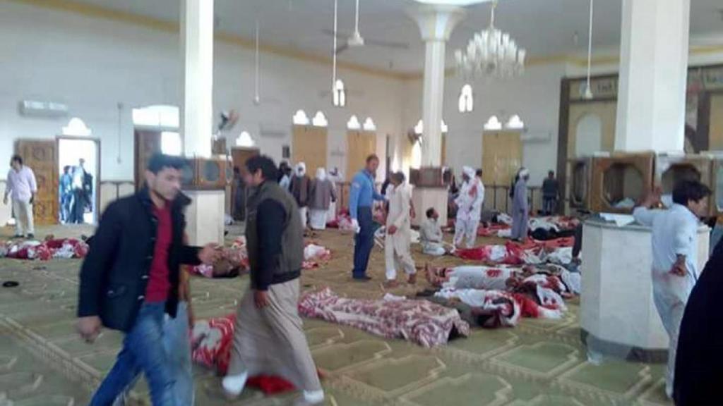 Varias personas permanecen junto a cuerpos sin vida en el interior de la mezquita en el Sinaí (Egipto)