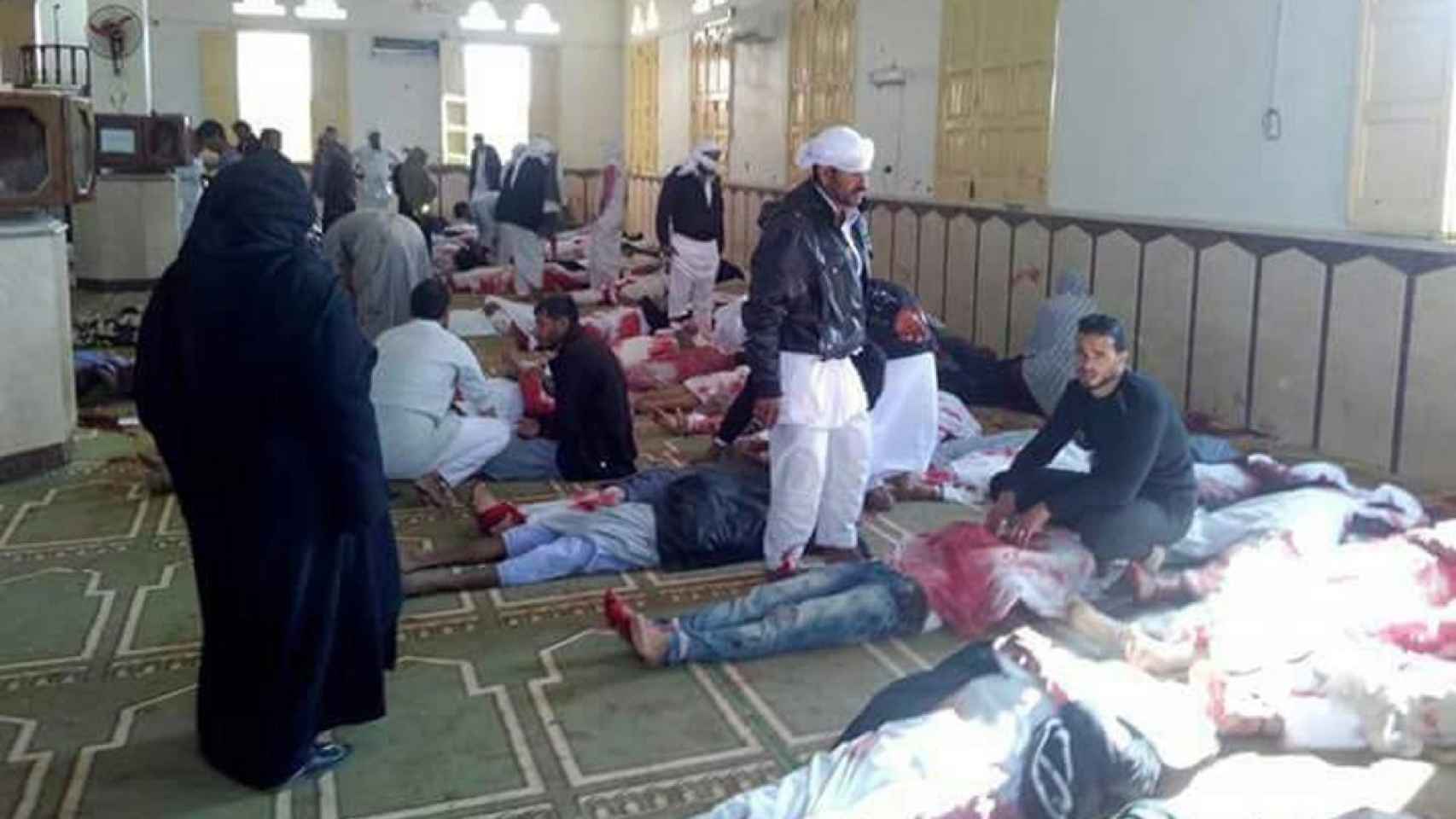 Varias personas permanecen junto a cuerpos sin vida en el interior de la mezquita.