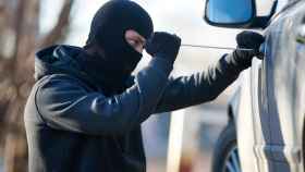 Imagen de archivo de un ladrón forzando la cerradura de un coche