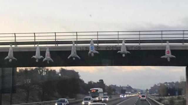 Los muñecos con logos del PP, Cs y PSC colgados de un puente en Cataluña. Foto: EP