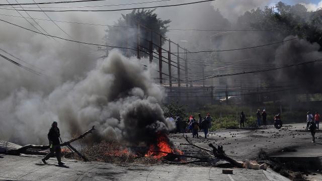 Simpatizantes de Nasralla levantan una barricada en medio de una carretera.