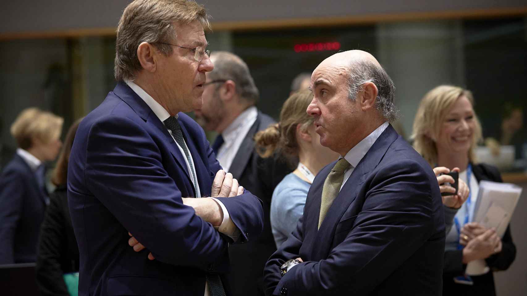 El ministro Guindos conversa con su homólogo belga durante el Ecofin