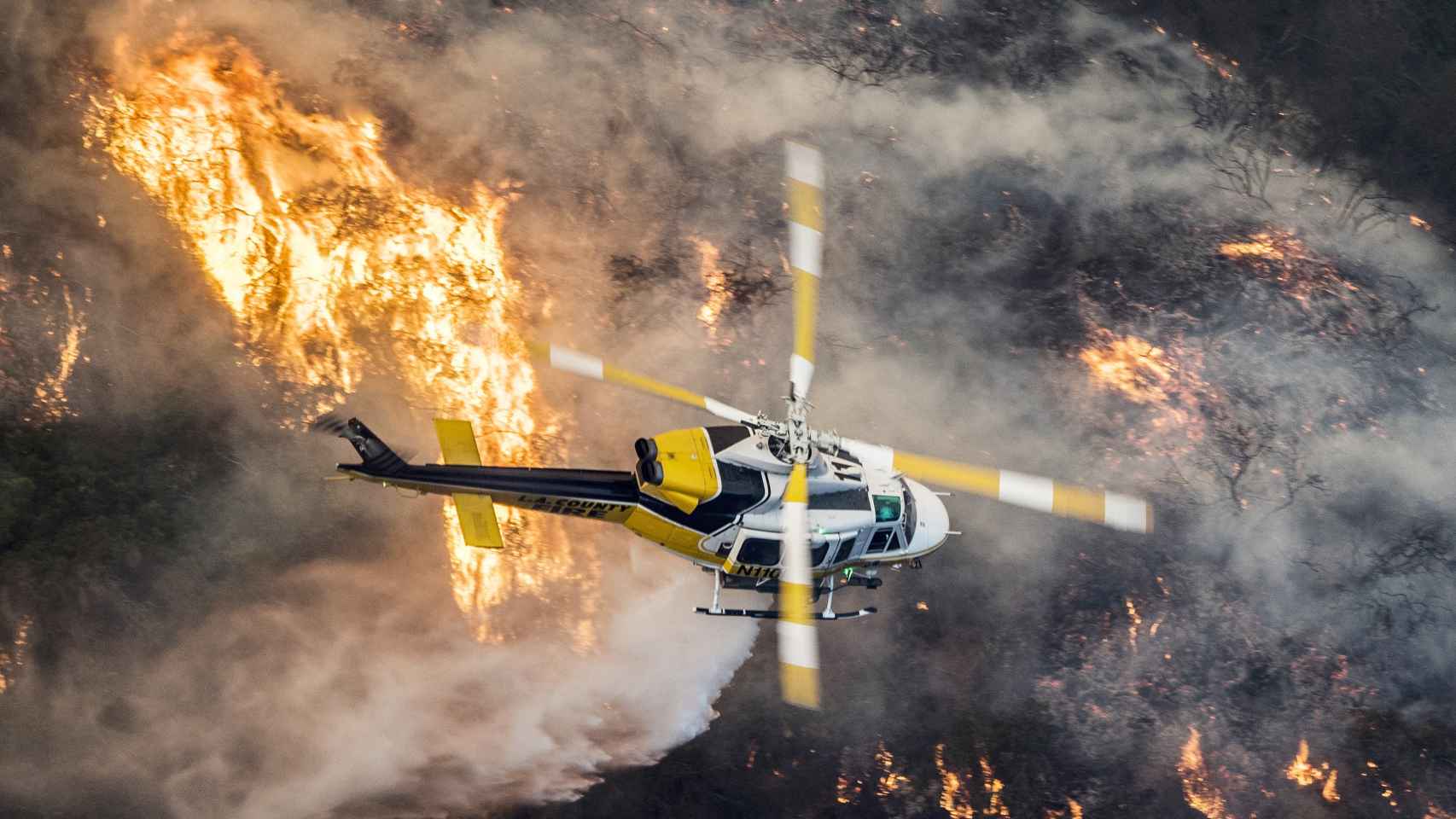 Un helicóptero de bomberos del Condado de Los Angeles sobrevuela un gran incendio en Bel Air. /Efe