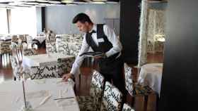 Imagen de recurso de un camarero montando una mesa.
