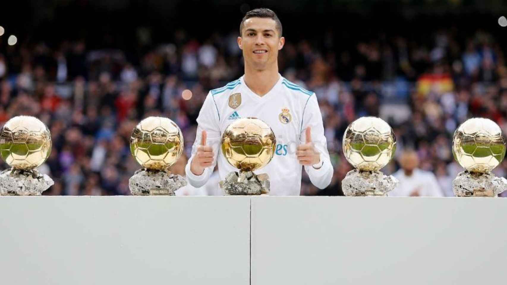 Cristiano posa con sus cinco balones de oro en el Santiago Bernabéu