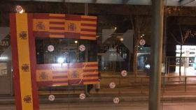 Una marquesina llena de pegatinas con las banderas de España y Cataluña.