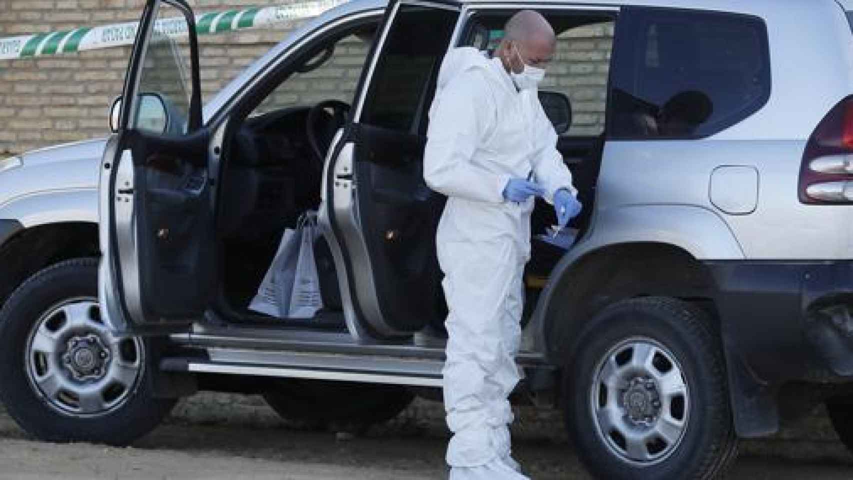 Un agente de la Policía Judicial de la Guardia Civil de Sevilla delante de uno de los coches usados por la banda de Pocholo.