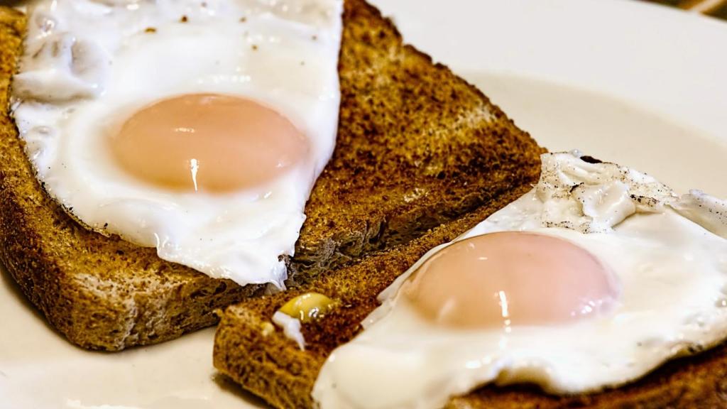 Un par de huevos fritos sobre dos rebanadas de sandwich.