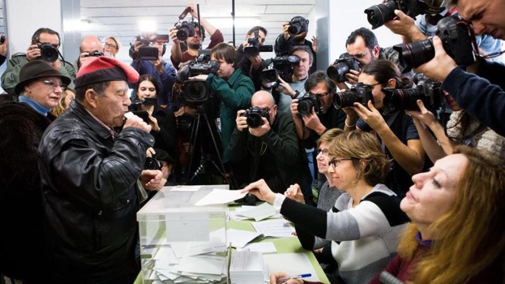 Un ciudadano con la típica barretina catalana, ejerce su derecho al voto en un colegio electoral.