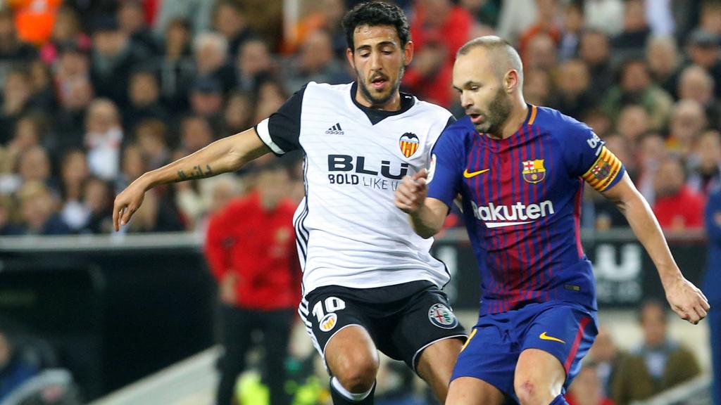 Iniesta conduce la pelota delante de Parejo.