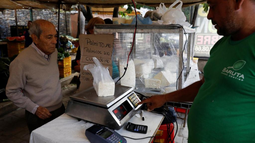 Un hombre comprando en un mercado venezolano.